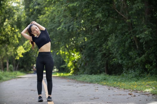 Portrait of beautiful female runner wearing workout clothe and warm up her body get ready for jogging in morning get good health. female runner warm up her body alone get ready for jogging in park. photo
