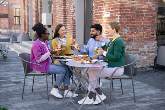 Friends sharing pizza and drinks outside photo