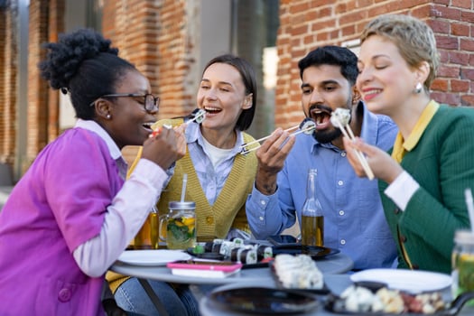 Friends eating sushi with chopsticks photo