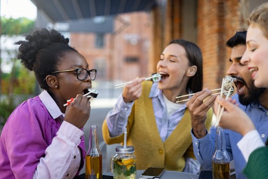 Group of friends eating sushi and laughing photo