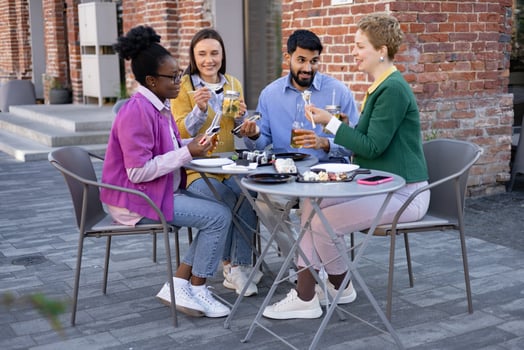 Diverse group of friends enjoying sushi and drinks at an outdoor cafe, socializing and having fun. photo