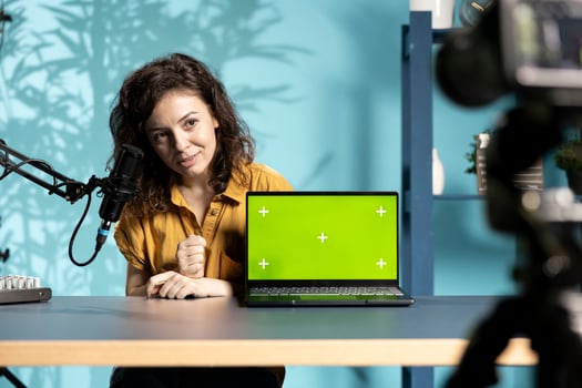 Tech specialist assessing mockup laptop performance, talking about parts used inside, filming with professional camera. Entertainer reviewing green screen notebook on technology internet channel photo