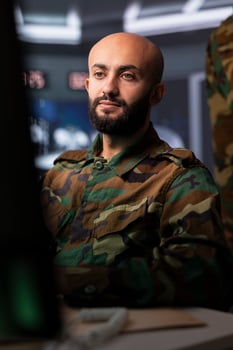 Air force combat control officer performing tactical level surveillance and reconnaissance using satellite gear. Middle Eastern military specialist using radar to search for potential assault zones photo