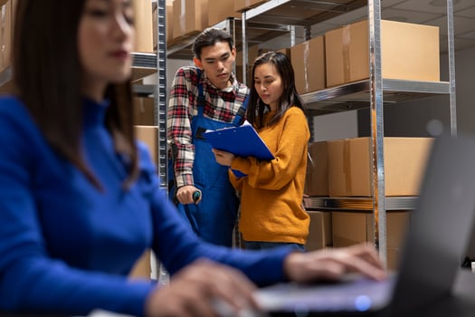 Asian staff member with reduced mobility on crutches prepares parcels in a storage room depot. Team managing in house logistics, order processing and small scale retail delivery. photo