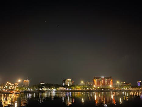 City lights reflect on the water creating a vibrant and captivating nighttime urban scene. photo