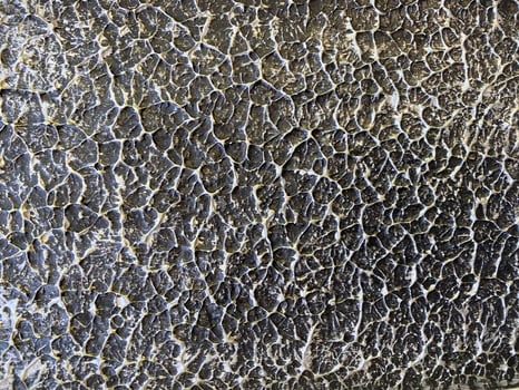 A close up of a black and white wall with cracks photo
