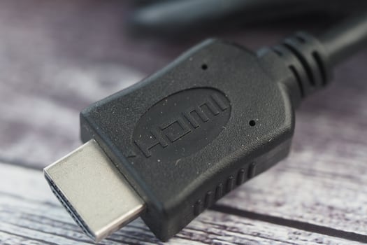 Close-up of a black HDMI cable connector on a wooden surface photo