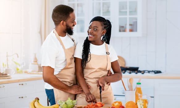 Romantic African American Spouses In Aprons Cooking Healthy Lunch At Home, Happy Black Man And Woman Enjoying Preparing Tasty Food Together, Making Fresh Vegetable Salad In Kitchen, Free Space photo