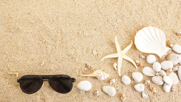 Top view of flat lay composition with sunglasses, starfish, and seashells isolated on beach sand background photo