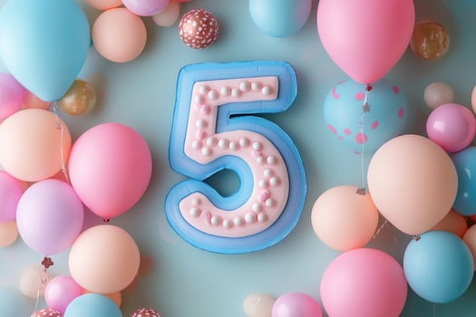 Fifth birthday celebration decorated with pastel balloons and number five photo