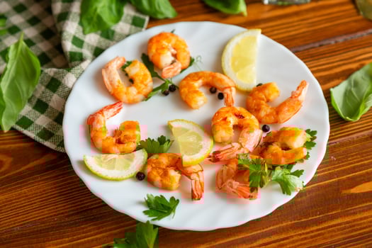 Cooking fried shrimps with aromatic spices and lemon in a plate on a wooden photo