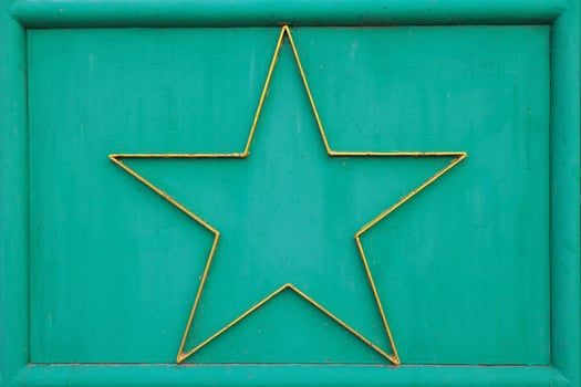 Abstract horizontal texture featuring green metal surface with decorative gold star framed at center. Vintage industrial look ideal for design, art or backgrounds. photo