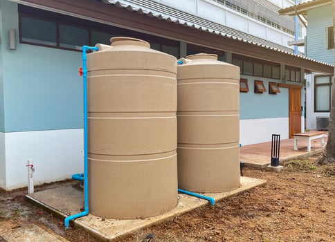 the water tank and water pump installed outside the building. For use as a reserve of water for use in homes and offices. Made of special grade material, extra thick, UV protection and not moss. photo