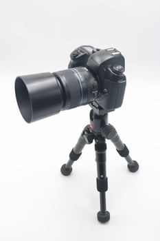 Camera on tripod positioned for capturing clear images in a studio setting with neutral background during indoor photography session photo
