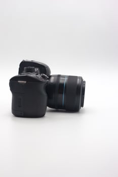Compact digital camera with lens positioned on a white background showcasing design details and features for photography enthusiasts photo