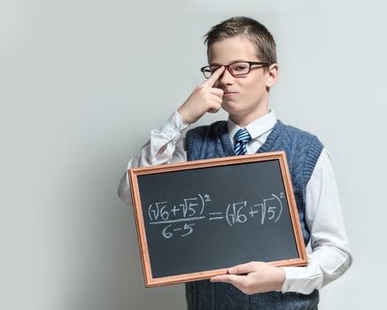 Clever schoolboy in glasses with mathematical equation photo