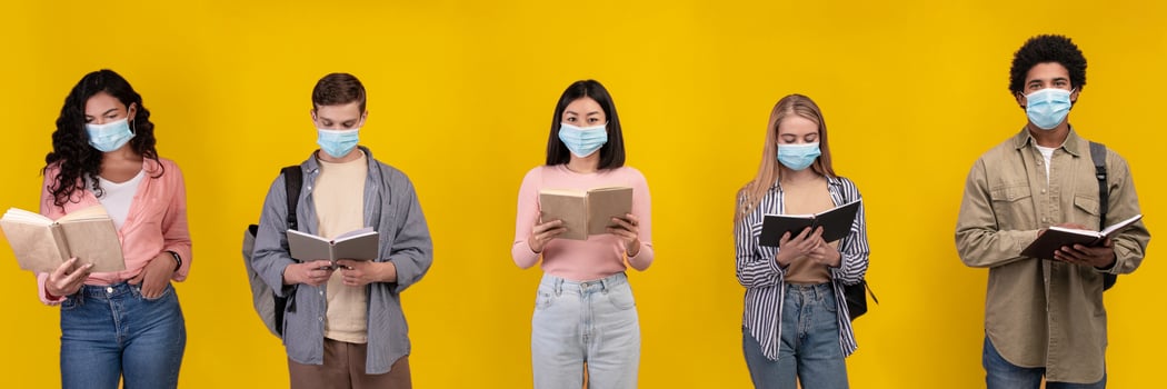 New normal, social distancing, test, education and covid-19 pandemic. Teens multiracial students in protective masks read books and abstracts isolated on orange background, panorama, copy space photo