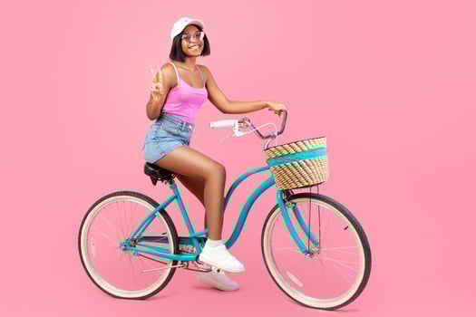 Woman on vintage bicycle with pink background photo