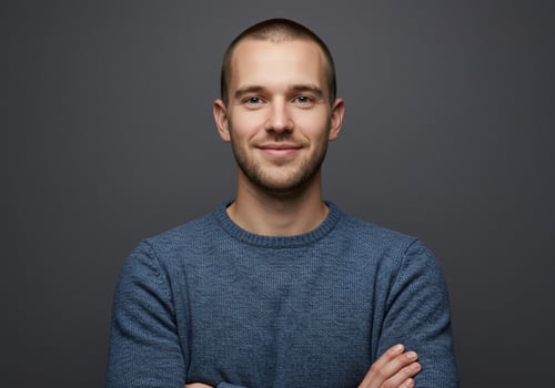 Portrait of a young man with arms crossed on a gray background photo