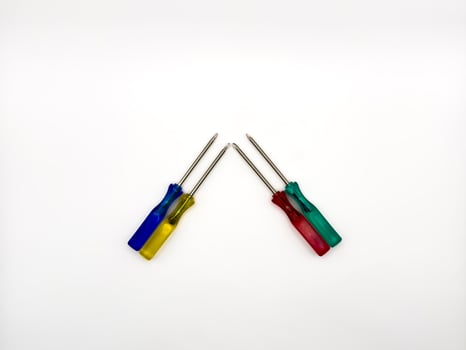 Four small colored plastic screwdrivers on a white background. copy space, flay lay photo
