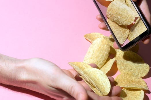 Potato Chips Dispensing from Smartphone into Hands photo