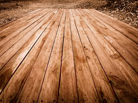 Weathered wooden planks laid out on a ground covered with dry leaves Texture photo