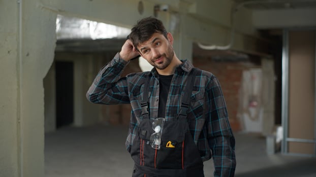 Man builder engineer on construction site working rubbing head thoughtful male Caucasian guy architect handyman foreman in uniform start work building technician electrician repairman industrial job photo