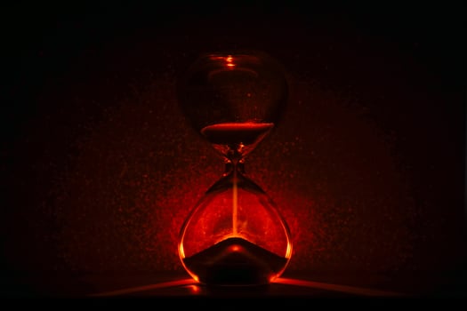 artistic glowing hourglass like sunrise or sunset, symbolizing time and creativity. Vibrant lighting against a dark minimalist backdrop. Concepts of time management, life balance, and artistic design. photo