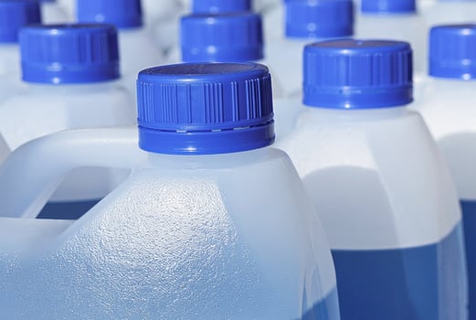 Plastic jars with blue liquid for windshield washer fluid close up photo