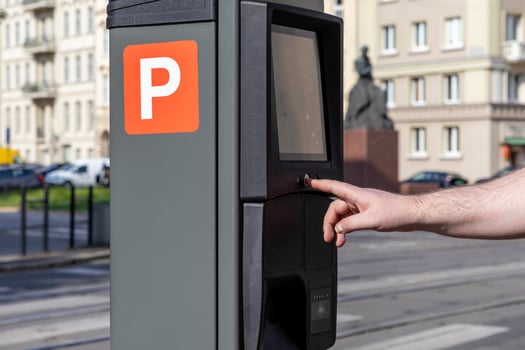 Human hand operates a modern city parking meter displaying an orange P sign for street payment, emphasizing urban mobility and efficient public service technology photo
