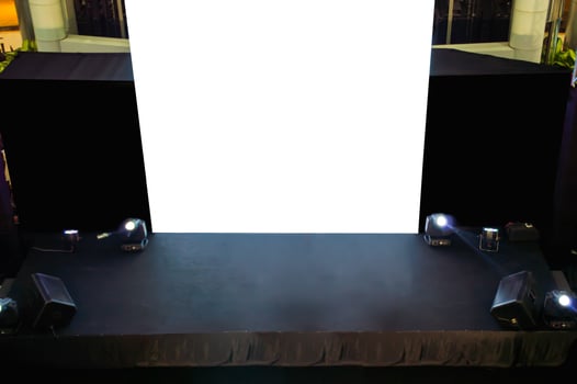 A stage with a white screen and a black curtain photo