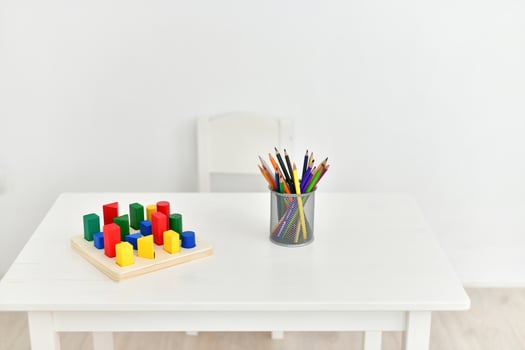 A white table with a wooden table and a wooden chair photo
