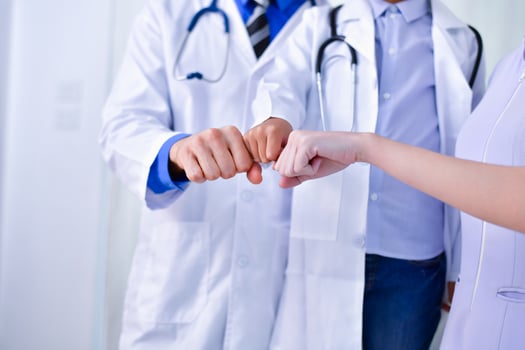 A doctor and two nurses holding hands photo