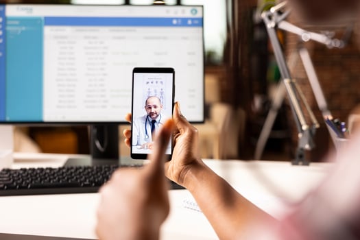 Selective focus on white male physician offering online consultation during call with african american patient. Caucasian doctor on virtual meeting assisting black individual remotely. photo