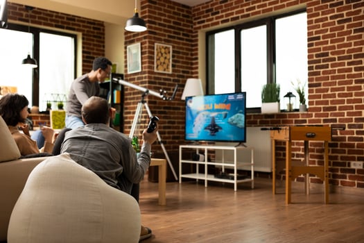 Diverse people bonding over successful game session, sharing smiles and cheers after win. Group of friends seated with gaming controllers, drinks and snacks nearby, filled with excitement. photo