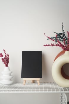 Display of decorative vases and a blank canvas on a shelf photo
