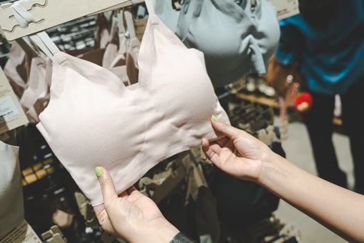Woman choosing bra in lingerie store. Female fashion, different sizes of underwear. Hands Choosing or Searching New Sexy Brassiere in Underwear Shop. Woman Shopping Bra. photo