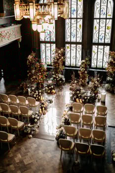Elegant indoor wedding venue with floral decor and stained glass windows photo