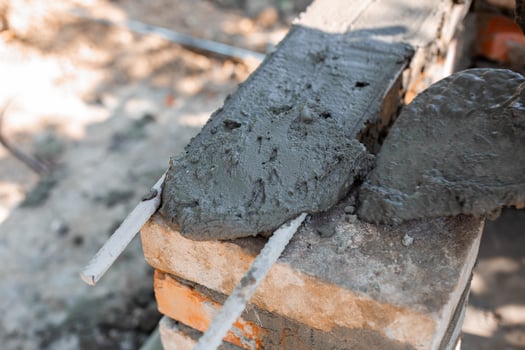 application wet cement on brick structure showing texture and process of barbecue construction. photo