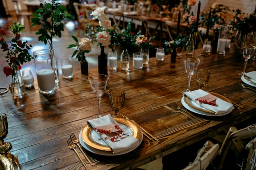 Elegant rustic wedding reception table setting with gold accents and floral decor photo