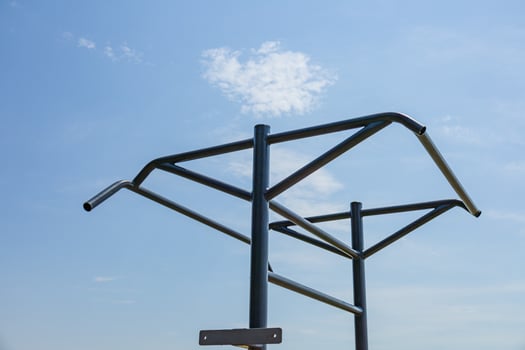 Parallel bars set against a clear blue sky encourage athletes to engage in gymnastics and strength training outdoors for fitness photo