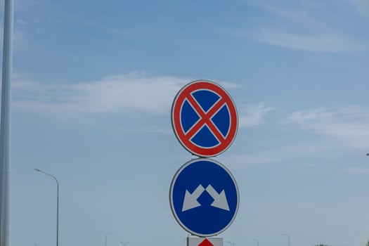 The clarity of a parking prohibition and mountain road sign stands tall against a blue sky, marking important driving regulations for motorists photo