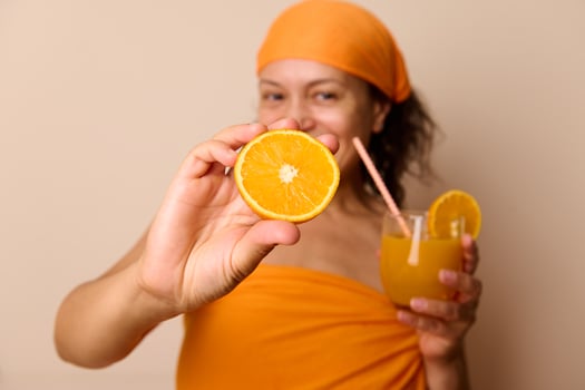 Vibrant Orange-Themed Portrait Featuring a Smiling Woman With Fresh Oranges and Juice photo