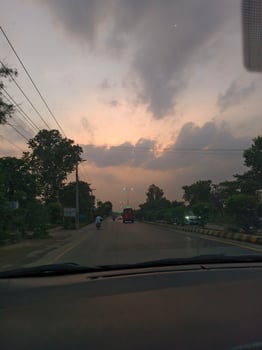 Driving on road at sunset with cloudy sky and trees landscape car view travel photography scenic highway photo