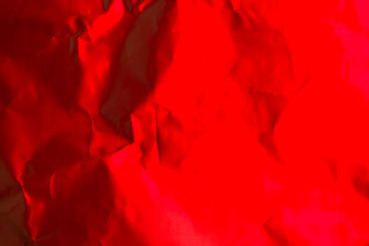 Bright red crumpled paper creates an artistic background for creative design or decoration purposes photo