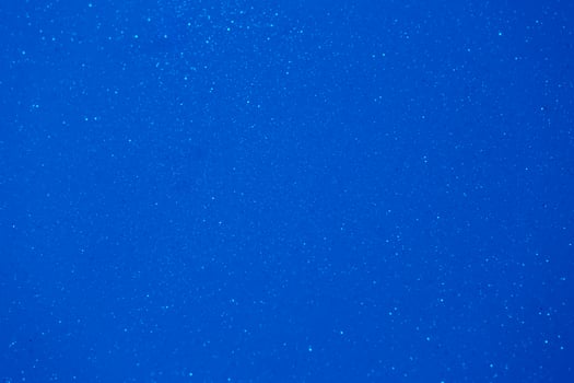 Deep blue background filled with shimmering particles creating a serene and tranquil atmosphere during sunset photo