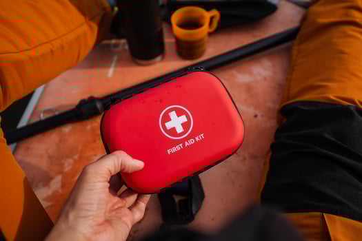 A person is firmly gripping a bright red first aid kit in their hands, fully prepared for any sort of emergency with all the essential medical supplies that are carefully stored inside photo