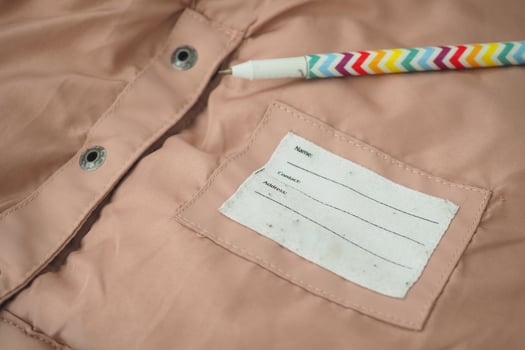 A label on soft pink fabric displays spaces for name and comments photo