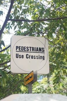 Sign directing pedestrians to use the crossing in a park photo
