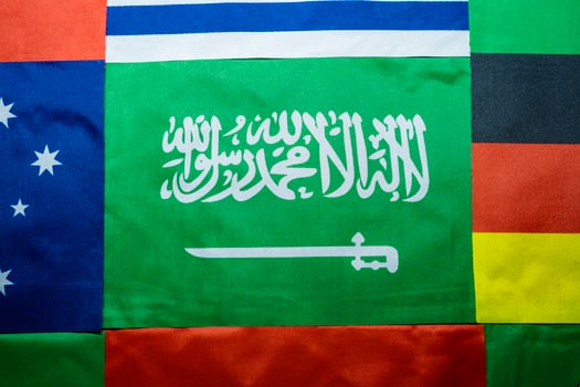 Saudi Flag Against a Multinational Flag Backdrop photo